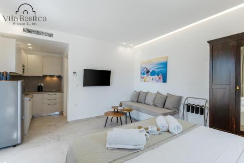 a white living room with a bed and a couch at Villa Basilica Tefsia in Perivolos