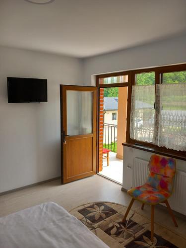 1 dormitorio con 1 cama, 1 silla y TV en Casa Lia Figa, en Beclean