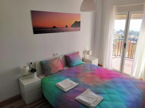 1 dormitorio con 1 cama con una manta colorida en Luminosa y confortable casa con vistas y piscina, en Jun