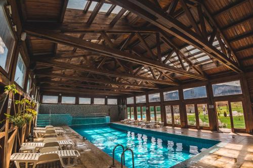 a pool in a building with chairs and a swimming pool at Thermal Hotel Seven Seasons in Banya