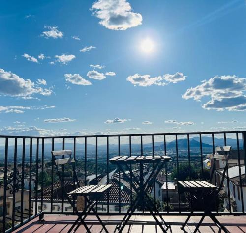 a table and chairs on a balcony with a view at Luminosa y confortable casa con vistas y piscina in Jun