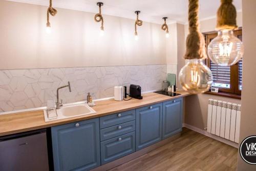 a kitchen with blue cabinets and a sink at Bulevard Apartments 11 in Alba Iulia