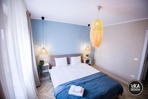 a bedroom with a large bed with a blue blanket at Bulevard Apartments 11 in Alba Iulia