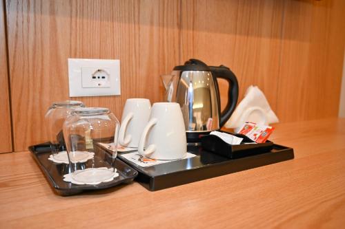 a tray with a tea pot and glasses on a table at Hotel Zanzi in Durrës