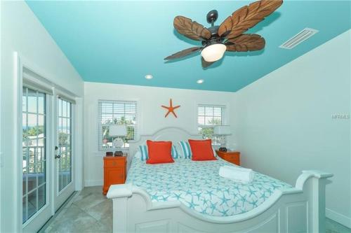 a bedroom with a bed with a ceiling fan at Footprints in the Sand managed by Beach Retreats in Holmes Beach