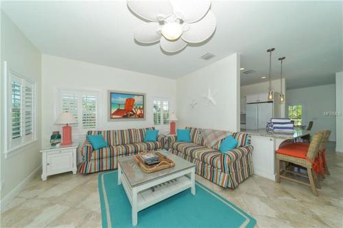 a living room with a couch and a table at Footprints in the Sand managed by Beach Retreats in Holmes Beach