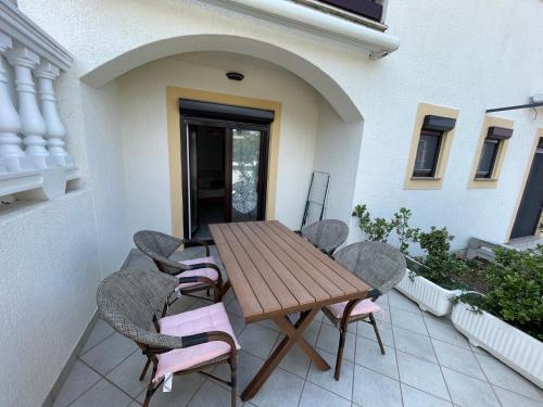 a wooden table and chairs on a patio at Apartment Kati in Crikvenica