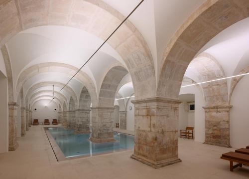 a large room with arched ceilings and a glass floor at Montebelo Mosteiro de Alcobaça Historic Hotel in Alcobaça