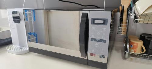 a microwave oven sitting on a kitchen counter at Platino, beside Paradigm Shopping Mall, free wi-fi, 4 bedrooms & 3 toilets, up to 12pax in Johor Bahru
