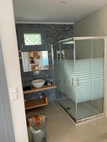 bagno con doccia in vetro e lavandino di ANAX SUITE a Pera Gyalos