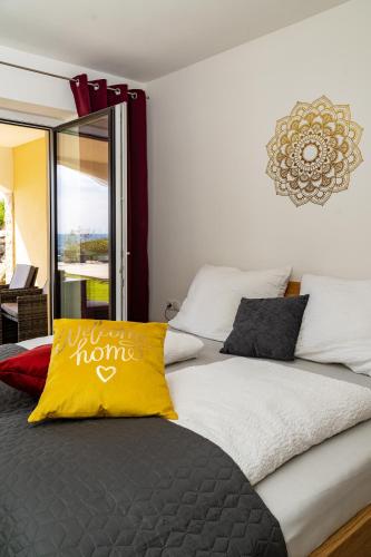 a bedroom with a bed with a yellow pillow at Urlaubsoase Hügelperle in Bad Gleichenberg