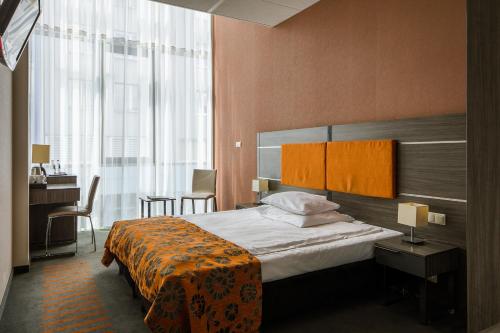 Pokój hotelowy z łóżkiem, biurkiem i oknem w obiekcie Hotel Centrum Business w Krakowie