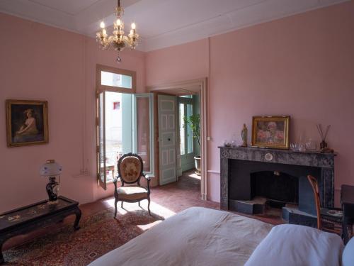 a bedroom with a fireplace and a bed and a chair at La maison odette in Aulas