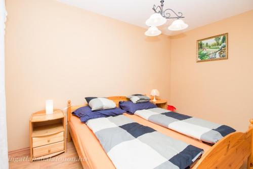 2 aparte bedden in een slaapkamer met 2 nachtkastjes bij 547 - Közvetlen vízparti, 2 hálószobás, kertkapcsolatos apartman in Balatonőszöd