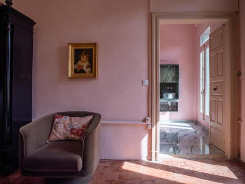 a living room with a chair and a picture on the wall at La maison odette in Aulas