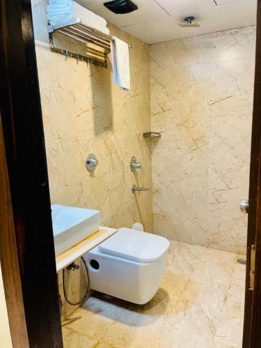 a bathroom with a white toilet and a sink at Hotel Embassy Park - BKC Mumbai in Mumbai