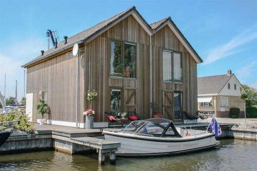 a boat is docked at a house on the water at Roggebroek 13 in Stavoren