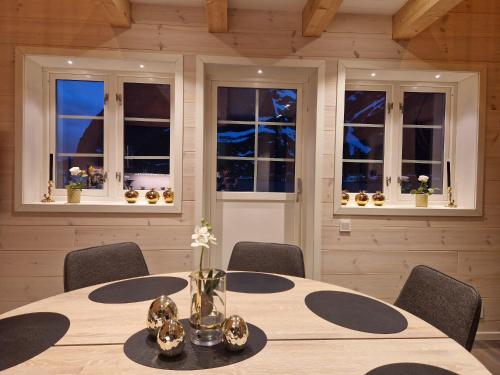 a dining room with a table with chairs and windows at Andøy Vest Rorbuer Reine in Reine