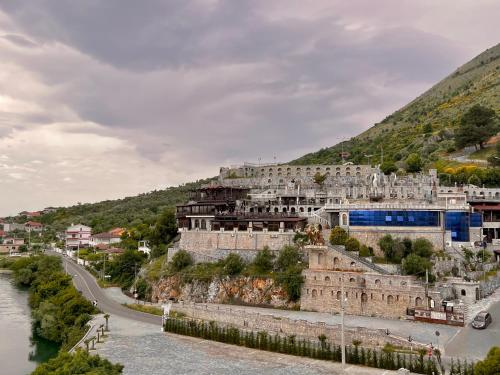 a building on a hill next to a river at Hotel Iliria in Shkodër