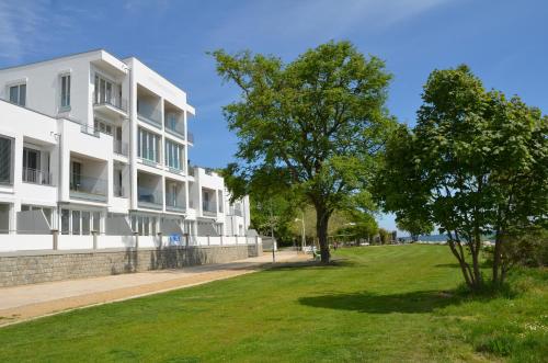 a large white building with trees in front of it at Ostseeresidenz Sassnitz F548 Penthouse 19 mit Sauna, Balkon, Meerblick in Sassnitz