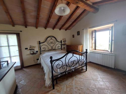 - une chambre avec un lit noir et 2 fenêtres dans l'établissement Casale le Piagge, à Roccastrada