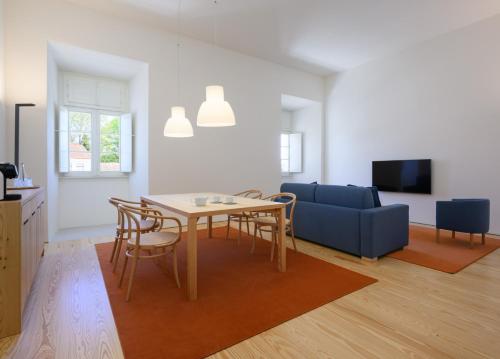 a living room with a table and a blue couch at Montebelo Mosteiro de Alcobaça Historic Hotel in Alcobaça