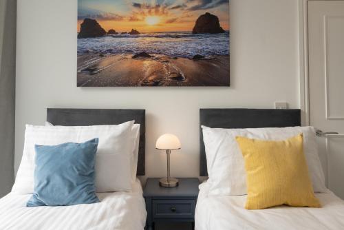 Un dormitorio con dos camas y un cuadro en la pared. en Church House - 2 Bed-Sleeps 4-TJS21CH, en Ilfracombe