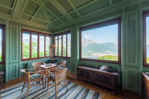 a room with green walls and windows with a table and chairs at Family Villa with Stunning Lake View by Wonderful Italy in Civenna