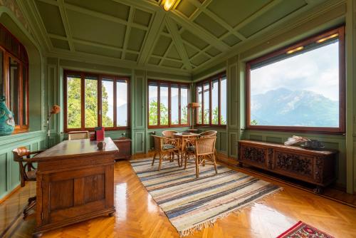a dining room with a table and chairs and windows at Family Villa with Stunning Lake View by Wonderful Italy in Civenna