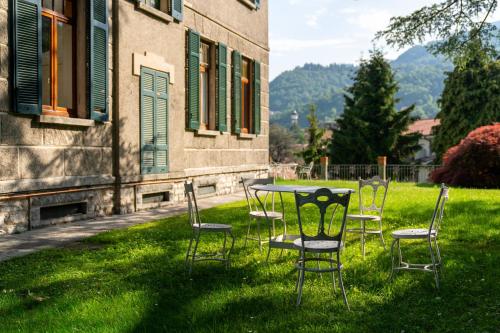 a table and chairs in the grass next to a building at Family Villa with Stunning Lake View by Wonderful Italy in Civenna