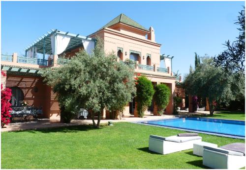 une grande maison avec une piscine dans une cour dans l'établissement Villa Palmeraie, à Marrakech