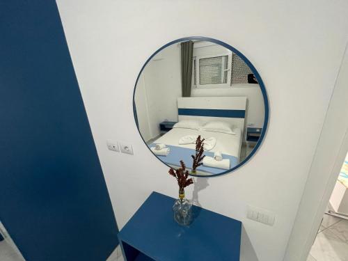 a mirror on a table in a room with a bed at Sky Apartments in Sarandë