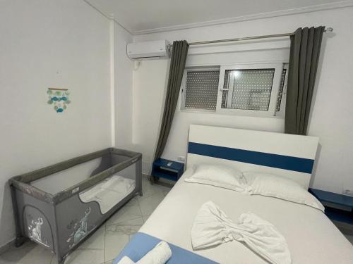 een kleine slaapkamer met een bed en een raam bij Sky Apartments in Sarandë