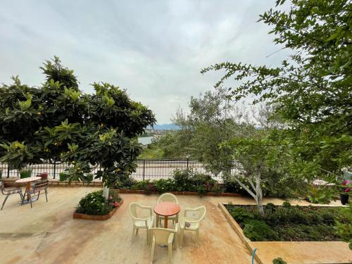 a patio with a table and chairs and trees at Sky Apartments in Sarandë