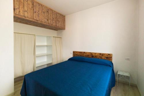 a bedroom with a bed with a blue blanket at Appartamento Per Due by HelloElba in Portoferraio