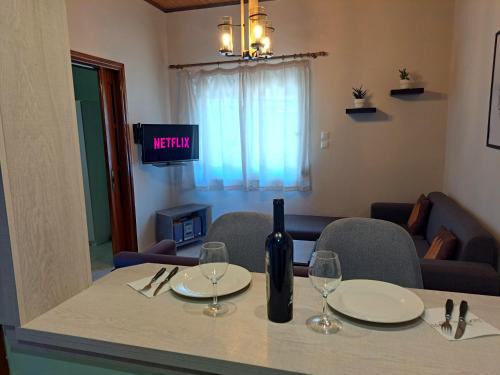 a table with a bottle of wine and two glasses at Olive tree villa in Ligia