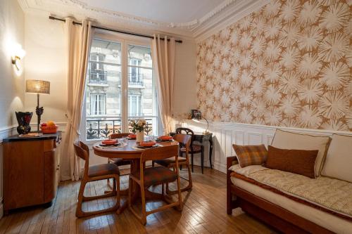 un salon avec une table et un canapé dans l'établissement Appartement de charme à Montmartre, à Paris