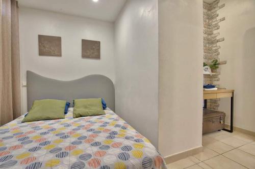 Un dormitorio con una cama con un edredón colorido. en Residence Provence plage, en La Ciotat