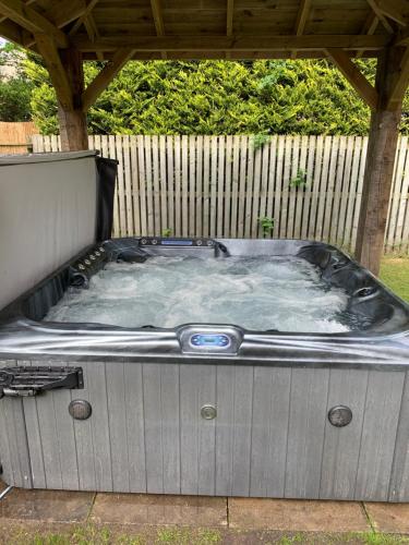 a hot tub sitting under a gazebo at Tanglewood Lodge in Lossiemouth