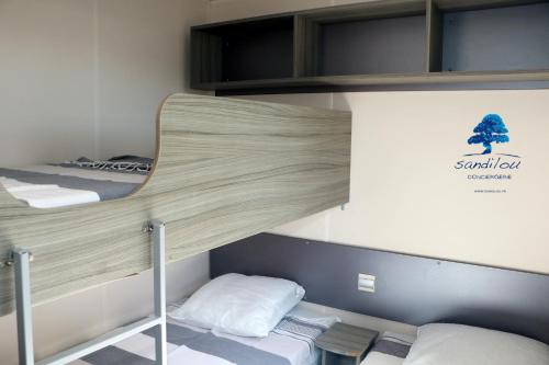 a room with two bunk beds in a dorm at Mobilhome «La mouette rieuse» * 6 personnes *Climatisatisé *2 Chambres in Sigean
