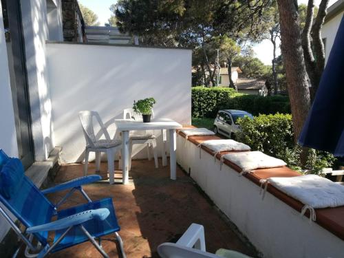 a patio with a white table and chairs on a wall at Casa Beatrice in Castiglioncello