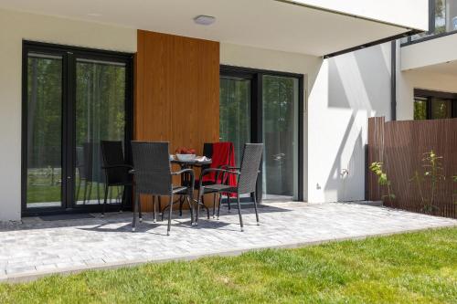 a patio with chairs and a table with a television at Plażowa Park Apartment with Garden by Noclegi Renters in Międzywodzie