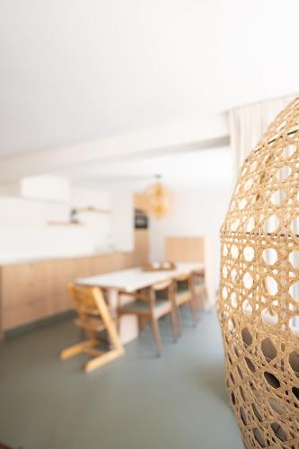 a table and chairs in a room with a table and a couch at Vista del Mar Japandi in Koksijde