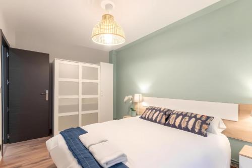 a bedroom with a large white bed and a lamp at Bilbao Urban City in Bilbao