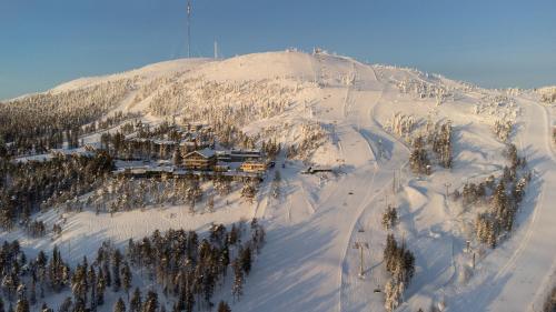 a snow covered mountain with a ski lodge on it at Ski-Inn Kultakero in Pyhätunturi