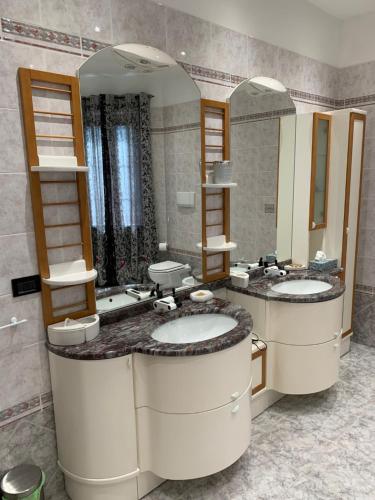 uma casa de banho com dois lavatórios e dois espelhos em B & B Villa Fiorella em Termoli
