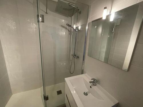 une salle de bain blanche avec une douche et un lavabo dans l'établissement Appartement climatisé pour 4 avec balcon et parking à Capbreton - FR-1-413-101, à Capbreton