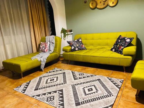 sala de estar con sofá amarillo y alfombra en City Center Green Apartment, en Bucarest