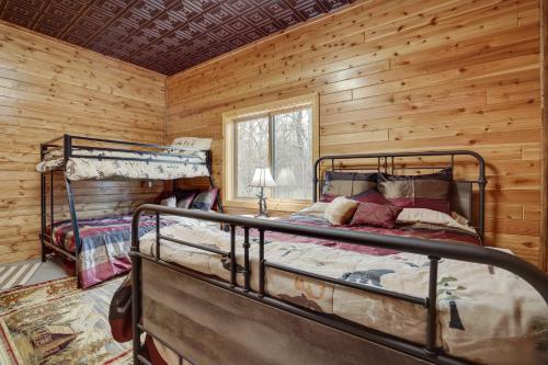 a bedroom with two bunk beds in a log cabin at Pet-Friendly Cabin Retreat Walk to Lake Pepin! in Stockholm
