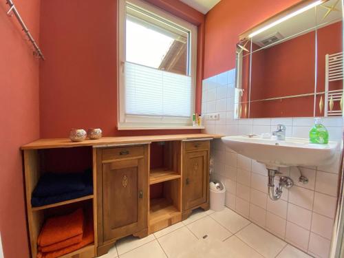 ein Bad mit einem Waschbecken und einem Spiegel in der Unterkunft Ferienwohnung Heide-Tukkul in Hermannsburg
